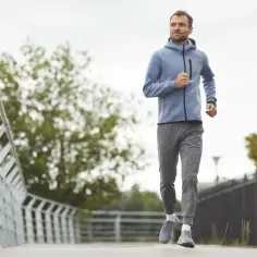 Mężczyzna w sportowym stroju biegnie po ścieżce. Idealny przykład, jak zacząć bieganie i cieszyć się ruchem na świeżym powietrzu.