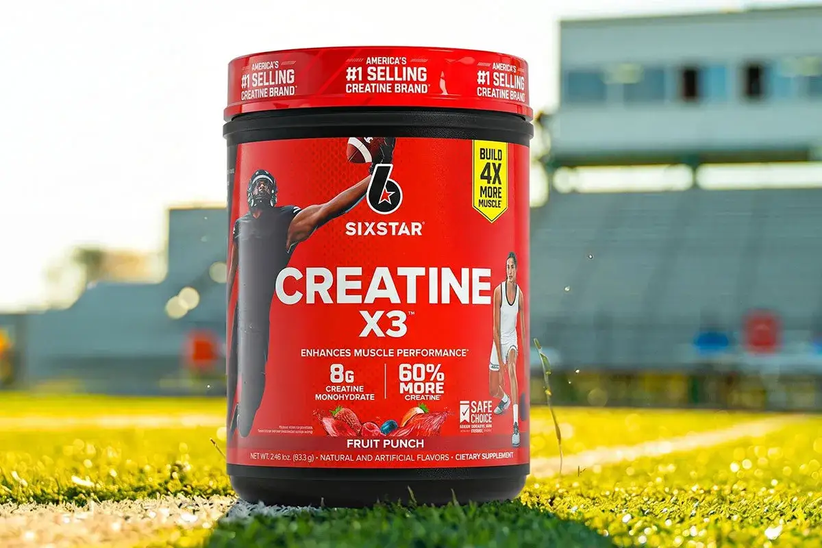 Pojemnik Sixstar Creatine X3 na tle stadionu. Zastanawiasz się, czy kreatyna przed czy po treningu da najlepsze efekty?